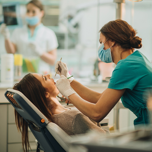 Young woman having her teeth checked during dental appointment at dentist's office.